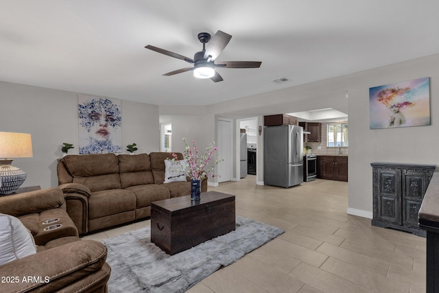 living room featuring ceiling fan and sink