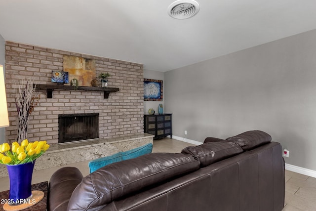 living room with a fireplace and light tile patterned floors