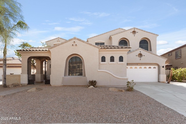 mediterranean / spanish home featuring driveway, an attached garage, a tiled roof, and stucco siding