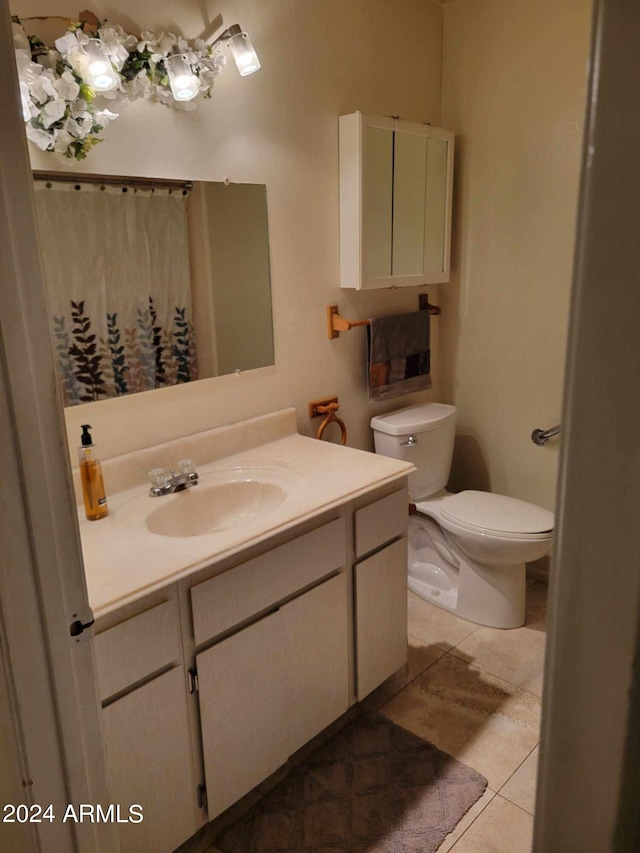 bathroom featuring toilet, vanity, and tile patterned floors