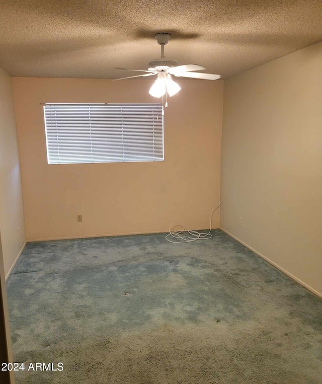 carpeted empty room featuring ceiling fan and a textured ceiling