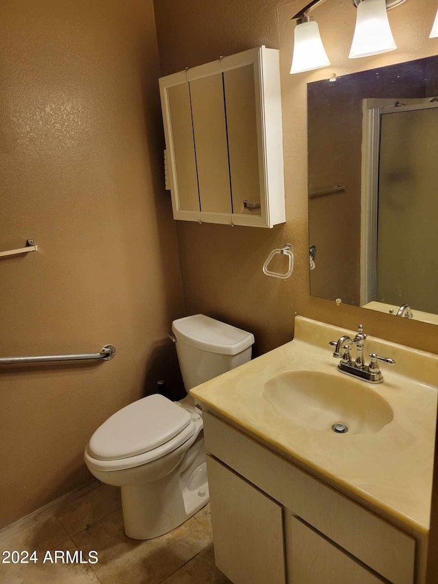 bathroom featuring toilet, vanity, tile patterned floors, and walk in shower