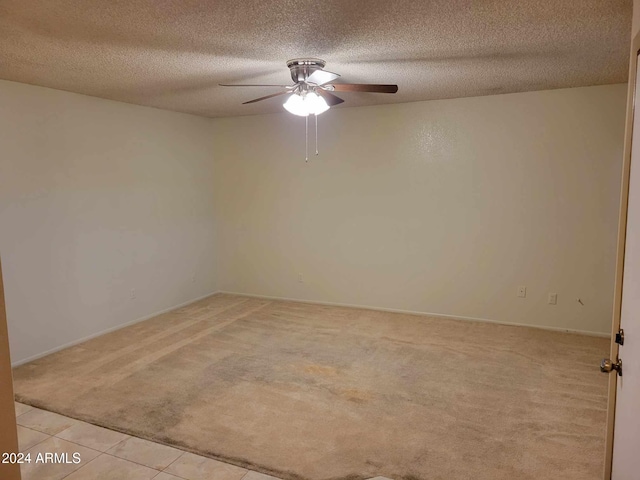 carpeted spare room featuring ceiling fan and a textured ceiling