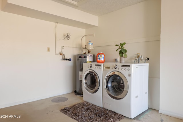 laundry area featuring separate washer and dryer, a textured ceiling, and water heater