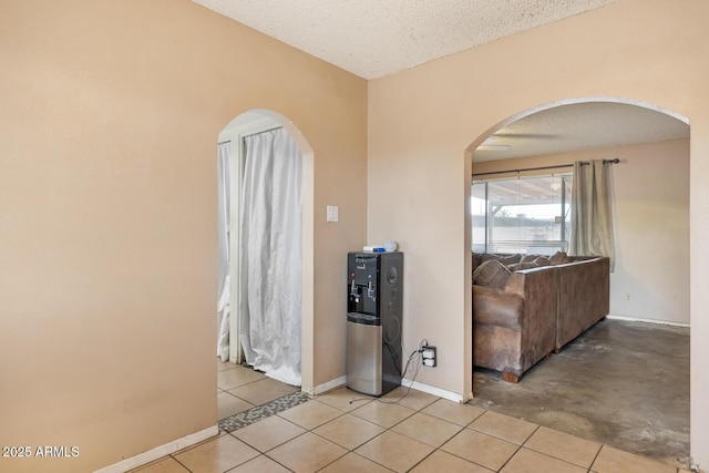 3410 W Pershing Ave, Phoenix, AZ 85029 - tiled empty room with arched walkways, baseboards, and a textured ceiling
