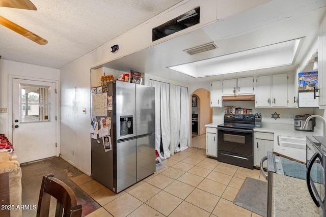3410 W Pershing Ave, Phoenix, AZ 85029 - kitchen with black range with electric stovetop, stainless steel fridge, a sink, arched walkways, and light countertops