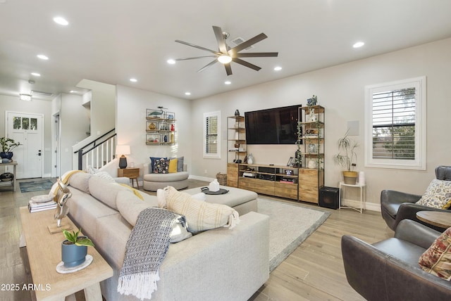 living room featuring ceiling fan and light hardwood / wood-style flooring