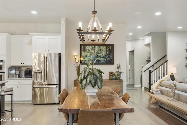 dining space featuring an inviting chandelier and light hardwood / wood-style flooring