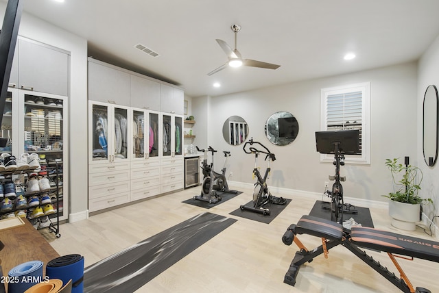 workout room featuring ceiling fan and light hardwood / wood-style flooring