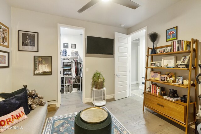 living area featuring light wood-type flooring and ceiling fan