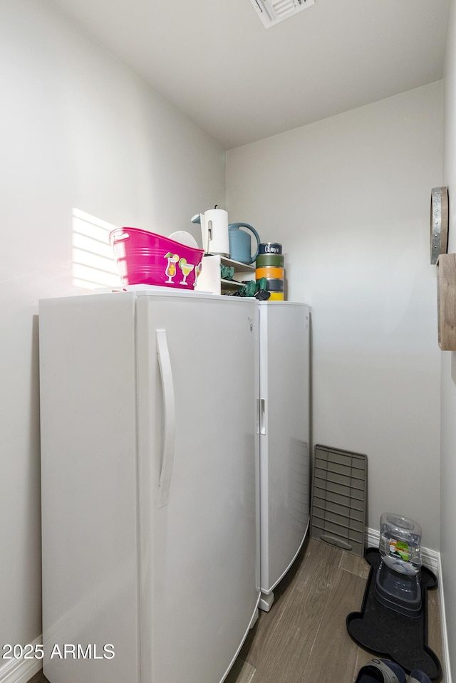 clothes washing area featuring independent washer and dryer and wood-type flooring