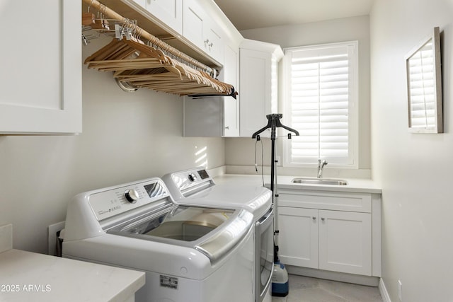 washroom with sink, cabinets, washer and dryer, and a healthy amount of sunlight