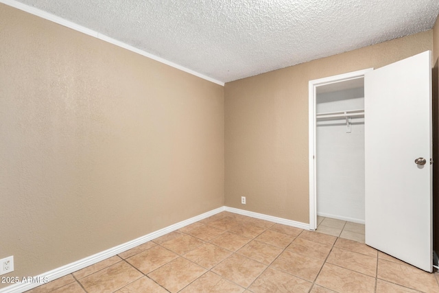 649 S Temple St, Mesa, AZ 85204 - unfurnished bedroom featuring light tile patterned flooring, a textured ceiling, a closet, and crown molding