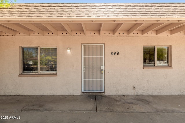 649 S Temple St, Mesa, AZ 85204 - doorway to property featuring roof with shingles, a patio area, and stucco siding