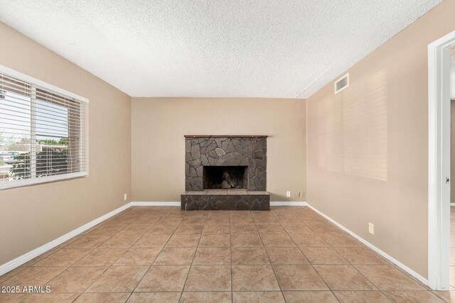 649 S Temple St, Mesa, AZ 85204 - unfurnished living room featuring a textured ceiling, a stone fireplace, and light tile patterned floors
