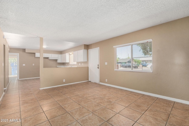 649 S Temple St, Mesa, AZ 85204 - empty room with plenty of natural light, a textured ceiling, light tile patterned floors, and baseboards