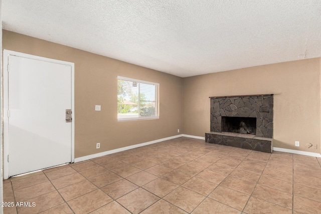649 S Temple St, Mesa, AZ 85204 - unfurnished living room featuring light tile patterned floors, a textured ceiling, a stone fireplace, and baseboards