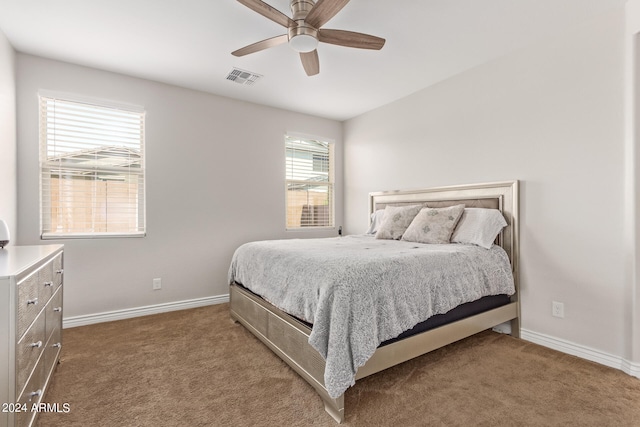 carpeted bedroom featuring ceiling fan and multiple windows