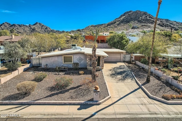 ranch-style home featuring a residential view, a mountain view, driveway, and stucco siding