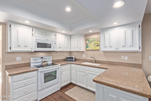 kitchen featuring white appliances, dark hardwood / wood-style floors, sink, and white cabinets