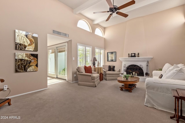 living room featuring ceiling fan, beam ceiling, a high ceiling, carpet floors, and a fireplace