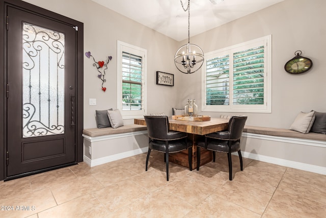 tiled dining room with an inviting chandelier