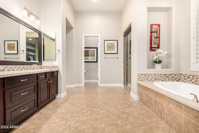 bathroom featuring tile patterned flooring, plus walk in shower, and vanity