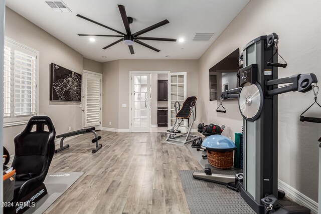 workout area with french doors, hardwood / wood-style floors, and ceiling fan