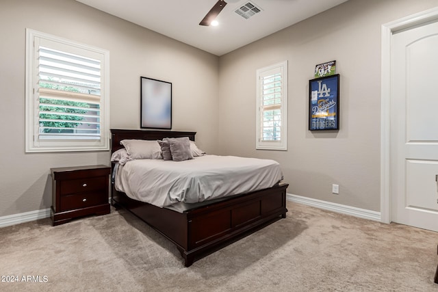 carpeted bedroom featuring ceiling fan and multiple windows