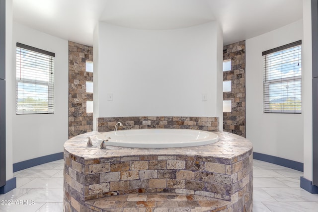 bathroom with a relaxing tiled tub