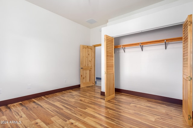 unfurnished bedroom with a closet and light wood-type flooring