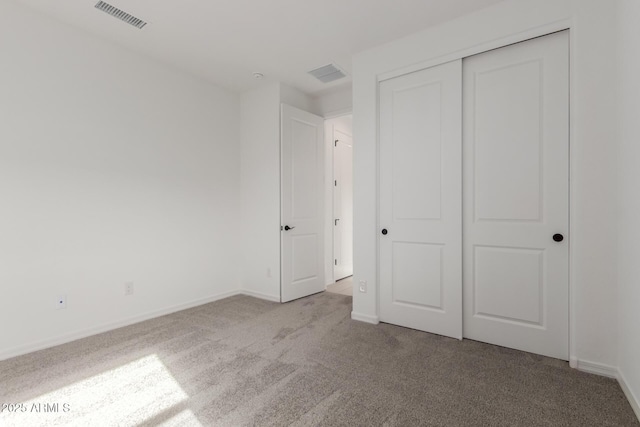 unfurnished bedroom with light carpet and a closet