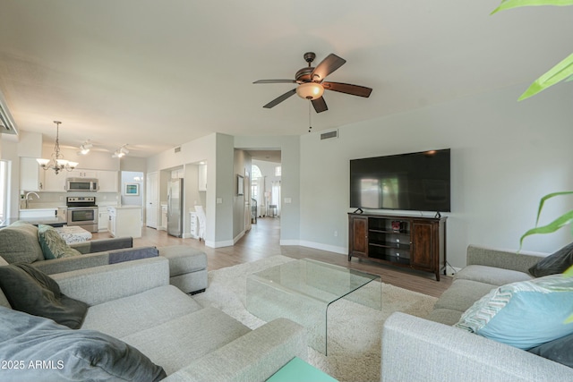 2218 E Anchor Dr, Gilbert, AZ 85234 - living area featuring visible vents, light wood finished floors, baseboards, and ceiling fan with notable chandelier