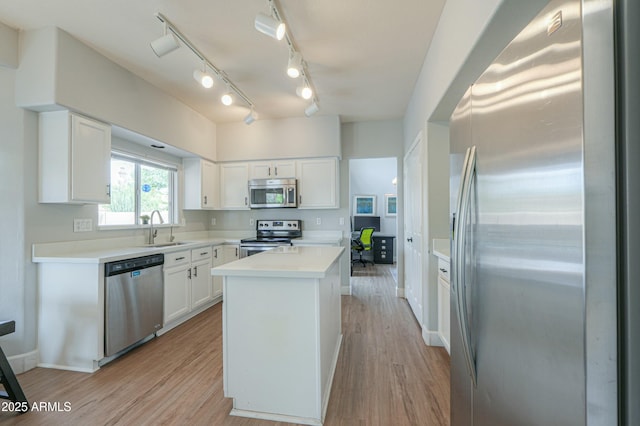 2218 E Anchor Dr, Gilbert, AZ 85234 - kitchen with white cabinets, a sink, light wood-style floors, a kitchen island, and appliances with stainless steel finishes