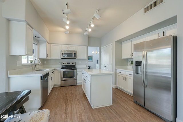 2218 E Anchor Dr, Gilbert, AZ 85234 - kitchen featuring stainless steel appliances, visible vents, a sink, light wood-style floors, and a center island