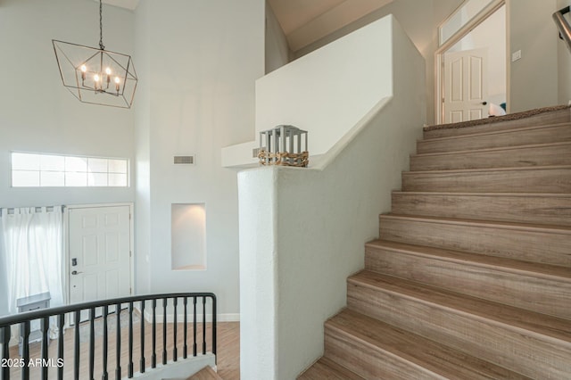 2218 E Anchor Dr, Gilbert, AZ 85234 - stairs with visible vents, wood finished floors, a high ceiling, and a chandelier