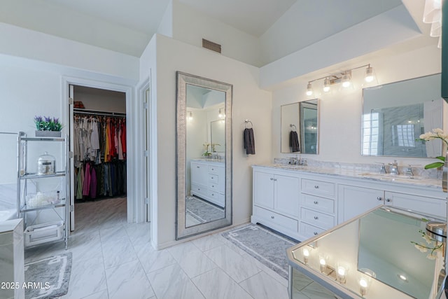2218 E Anchor Dr, Gilbert, AZ 85234 - bathroom featuring a walk in closet, double vanity, and a sink
