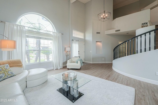 2218 E Anchor Dr, Gilbert, AZ 85234 - living area featuring wood finished floors, a high ceiling, an inviting chandelier, and a healthy amount of sunlight