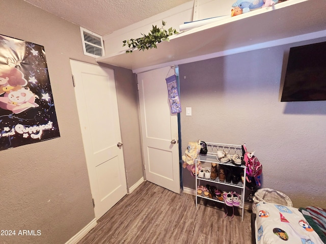 bedroom with hardwood / wood-style flooring and a textured ceiling