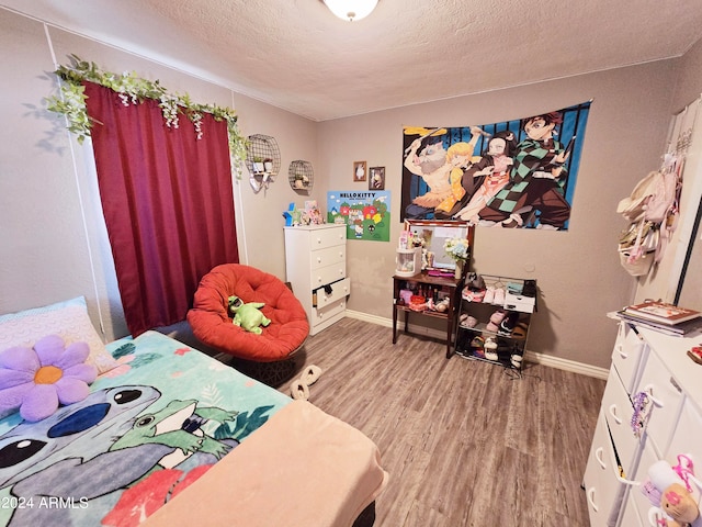 bedroom featuring wood-type flooring and a textured ceiling