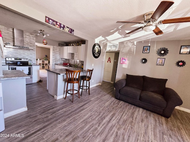 living room with a textured ceiling, dark wood-type flooring, sink, and ceiling fan