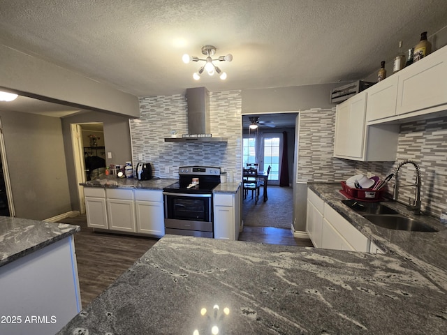 kitchen with stainless steel range with electric cooktop, sink, white cabinetry, wall chimney exhaust hood, and tasteful backsplash