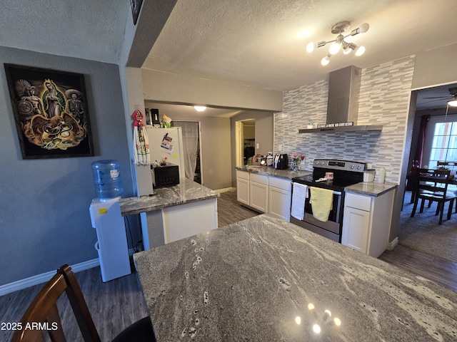 kitchen featuring dark wood-type flooring, electric stove, wall chimney range hood, stone countertops, and white cabinets