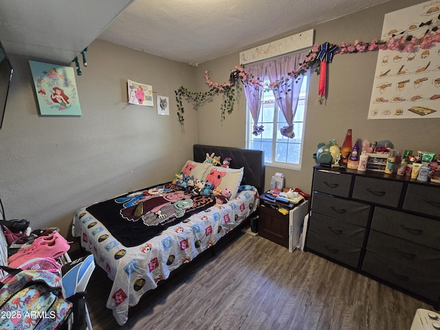 bedroom featuring wood-type flooring and a textured ceiling