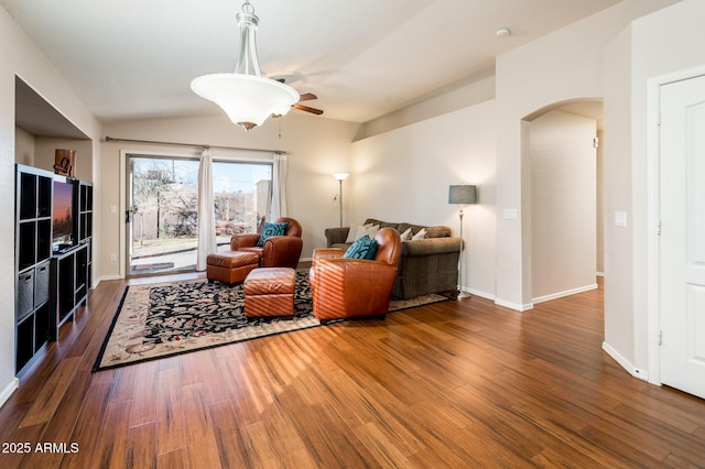 living room with ceiling fan, dark hardwood / wood-style flooring, and lofted ceiling