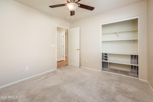 unfurnished bedroom featuring light carpet, a closet, and ceiling fan