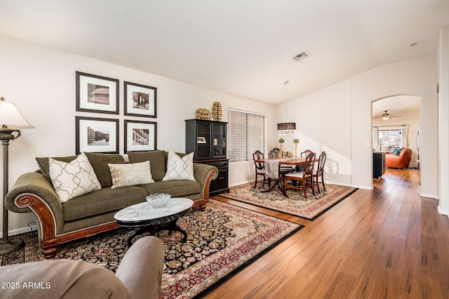 living room with ceiling fan, dark wood-type flooring, and lofted ceiling