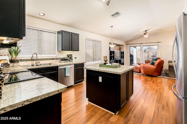 kitchen featuring stainless steel appliances, sink, a center island, ceiling fan, and hanging light fixtures