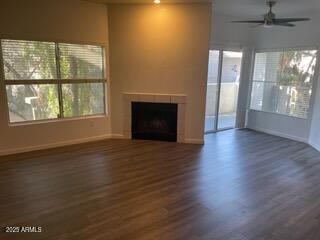 unfurnished living room featuring dark hardwood / wood-style floors and ceiling fan