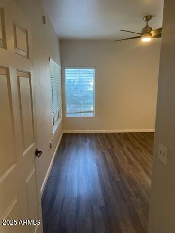 unfurnished room with dark wood-type flooring and ceiling fan